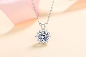 Macro shot of silver sunflower pendant with heart cutouts and bright center stone