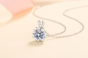 Macro shot of snowflake pendant with brilliant cut center stone on fine silver chain