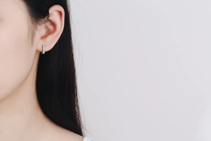 Gros plan de créoles en argent S925 avec pavage de moissanite couleur D sur l'oreille