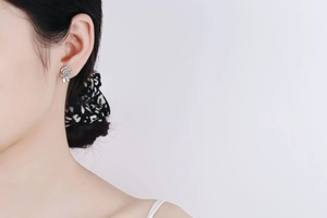 Close-up of S925 silver rose earrings with moissanite diamonds on model ear