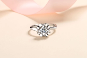 Macro shot of silver floral ring with heart-shaped petals and brilliant center gemstone