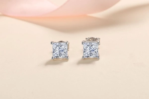 Macro shot of Princess Cut silver stud earrings with four-prong settings and clear stones