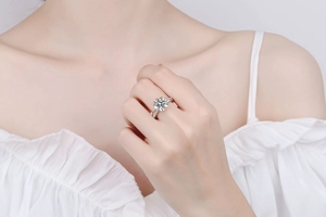 Détail d'une bague en argent S925 avec moissanite motif fleur sur le doigt