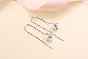 Detailed view of S925 silver cube earrings with long tassels and moissanite stone