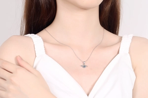 Nahaufnahme der S925 Silber Engelsflügel-Kette mit funkelndem blauen Rundstein