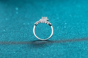 Macro detail of silver ring with sparkling clusters of cubic zirconia stones on blue sequins