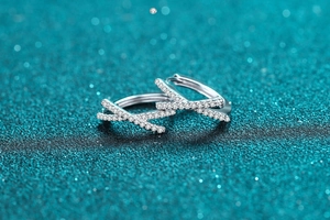 Close-up of S925 silver criss-cross hoop earrings with white moissanite stones