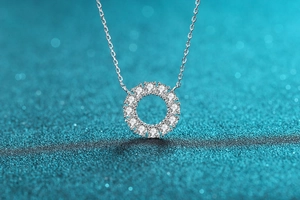Macro shot of S925 silver round pendant with 12 sparkling stones on a blue glitter background