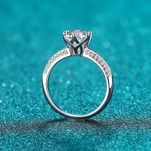 Elegant 925 silver ring with six-claw moissanite and pave diamonds on a teal background