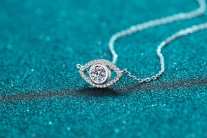 Macro shot of S925 silver Evil Eye pendant with moissanite center stone on blue background