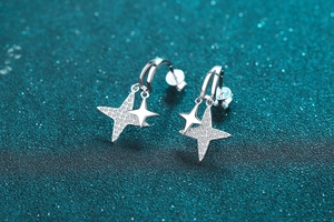 Gros plan sur des boucles d'oreilles étoile en argent S925 avec moissanite et fini poli