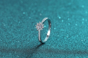 Macro shot of S925 silver moissanite ring with snowflake flower setting on glitter background