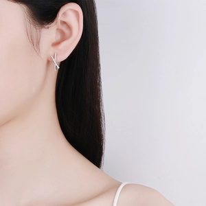Elegant S925 silver cross hoop earrings with moissanite stones shown on a model side profile