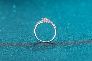 Close-up of a S925 silver crown ring with a round moissanite and pave-set side stones