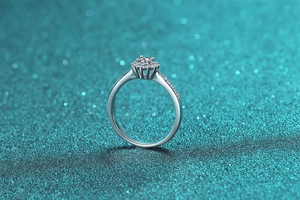 Close-up of S925 silver moissanite ring with halo setting on shimmering background