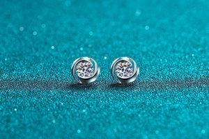 Macro shot of S925 sterling silver swirl earrings with round moissanite center stones