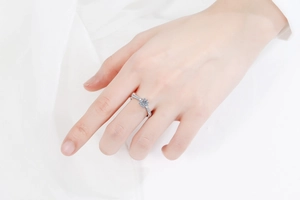 Close-up of snowflake sterling silver ring with moissanite center on a woman's finger