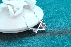 Détail du pendentif croisé en argent S925 avec pierres de moissanite sur chaîne fine