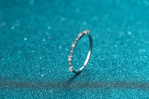 Macro side view of thin 925 sterling silver ring with alternating round moissanite stones
