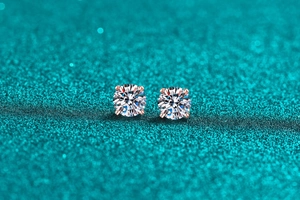Macro shot of 925 silver four-prong moissanite stud earrings in rose gold finish