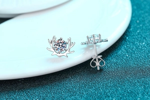 Macro view of S925 sterling silver reindeer earrings with 4-prong moissanite setting
