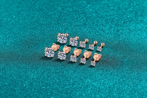 Detail of five different sized rose gold four-claw stud earrings with clear stones