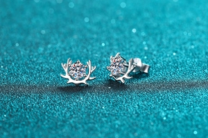 Macro shot of silver reindeer antler earrings with sparkling round moissanite center stones