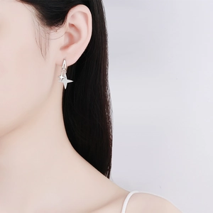 Boucles d'oreilles pendantes étoile en argent S925 avec pavé de pierres sur un mannequin
