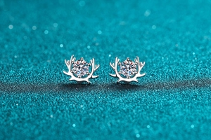 Macro shot of S925 sterling silver reindeer horn earrings with 50-point moissanite gems
