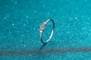 Macro detail of three-stone Moissanite S925 silver ring with blue sparkle background