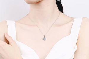 Close-up of S925 sterling silver necklace featuring a round light blue moissanite pendant