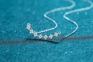 Macro side view of S925 sterling silver necklace with curved diamond floral pendant