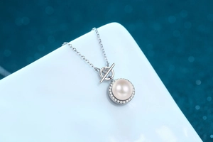 Detailed close-up of a 9mm pearl necklace with Moissanite pavé and stylish OT buckle clasp