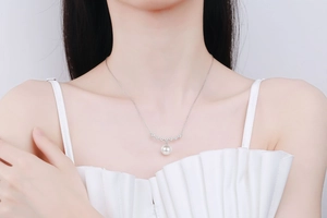 Close-up of S925 sterling silver four-leaf clover necklace with round white pearl pendant