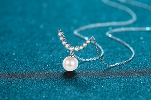 Macro d'un collier de perles d'eau douce 8mm avec pendentif courbé serti de brillants fins