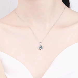 S925 sterling silver necklace featuring a swirling round moissanite pendant on a model