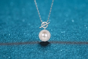 Close-up of elegant 9mm freshwater pearl pendant with moissanite pave on glitter background