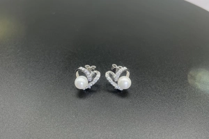 Détail de boucles d'oreilles cœur en argent S925 avec perles d'eau douce et pavés