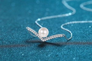 Macro view of S925 silver V-shaped pendant necklace with 8mm freshwater pearl and moissanite