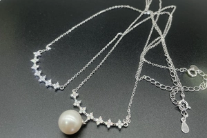 Macro shot of S925 sterling silver necklace with sparkling clover crystals and pearl pendant