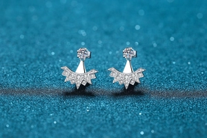 Gros plan de boucles d'oreilles flocon en argent et zircone sur fond bleu foncé