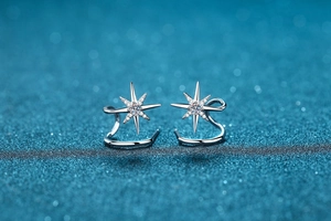 Close-up of snowflake star stud earrings in 925 silver with sparkling moissanite stones