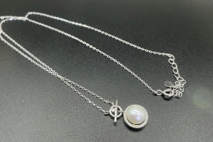 Detailed shot of S925 silver necklace with white pearl pendant and elegant OT clasp design