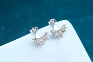 Macro de boucles d'oreilles flocon en argent 925 avec zircon sur fond bleu effet bokeh