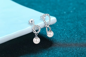 Detail view of S925 sterling silver knot earrings with pearls and pavé stones