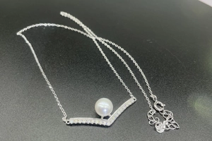 Close-up of S925 silver V-shaped pendant with freshwater pearl and moissanite inlay