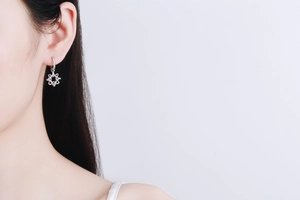 Detail view of S925 sterling silver hoop earrings with a hexagon moissanite snowflake charm