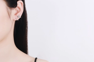 Close-up of 925 silver star earring with blue zircon stone worn by a female model