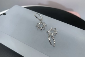 Macro detail of S925 sterling silver hoop earrings with shimmering star-shaped pendants