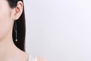 Macro detail of minimalist S925 sterling silver tassel earring with round moissanite stone